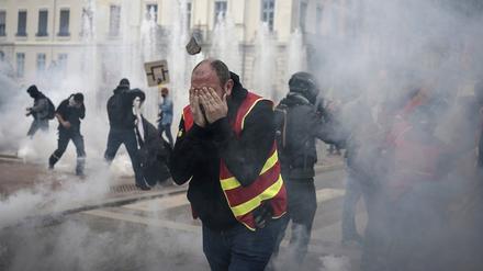 Demonstranten rennen während einer Demonstration durch Tränengas. 