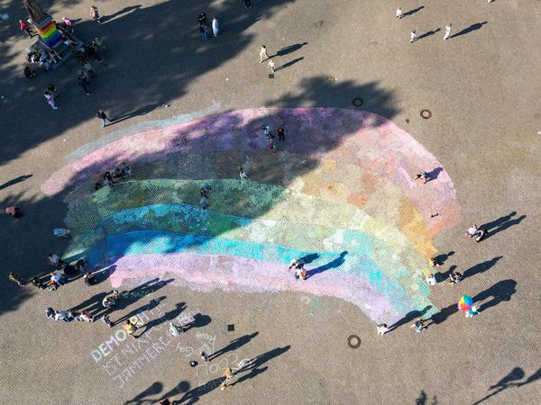 Stunden zuvor treffen sich vor allem Familien und bemalen auf Initiative des Bürgermeisters den Schlossplatz der Stadt mit einer großen Regenbogenfahne.