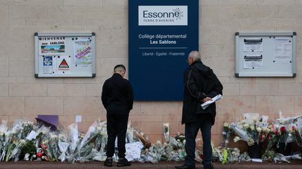 Anwohner betrachten die Blumen, die vor dem Eingang der Mittelschule Les Sablons in Viry-Chatillon niedergelegt worden sind nach dem gewaltsamen Tod eines 15-jährigen Schülers. 