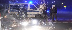 Berliner Polizeibeamte stehen hinter explodierendem Feuerwerk. 