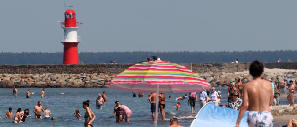 Badegäste genießen die Sonne am Ostseestrand. Am Wochenende meldet sich der Hochsommer mit entsprechenden Temperaturen zurück. 