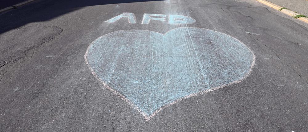 Ein blaues Herz und der Schriftzug AfD sind mit Kreide auf eine Straße gemalt am Tag der Stichwahl des Landrats im Landkreis Sonneberg. 