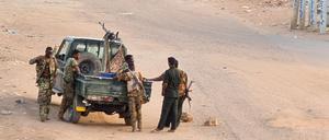 Soldaten der sudanesischen Armee stehen am 20. Mai 2023 neben ihrem Fahrzeug auf einer mit Ziegelsteinen blockierten Straße in Khartum.