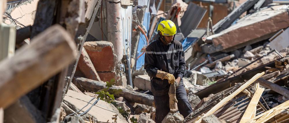 Ein Retter sucht in Marokko in Trümmern nach Überlebenden.