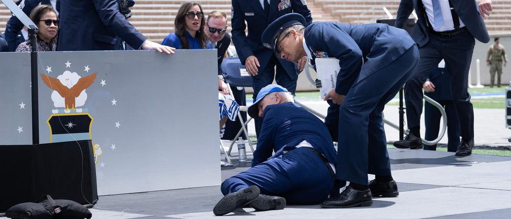 TOPSHOT - US President Joe Biden is helped up after falling during the graduation ceremony at the United States Air Force Academy, just north of Colorado Springs in El Paso County, Colorado, on June 1, 2023. (Photo by Brendan Smialowski / AFP)