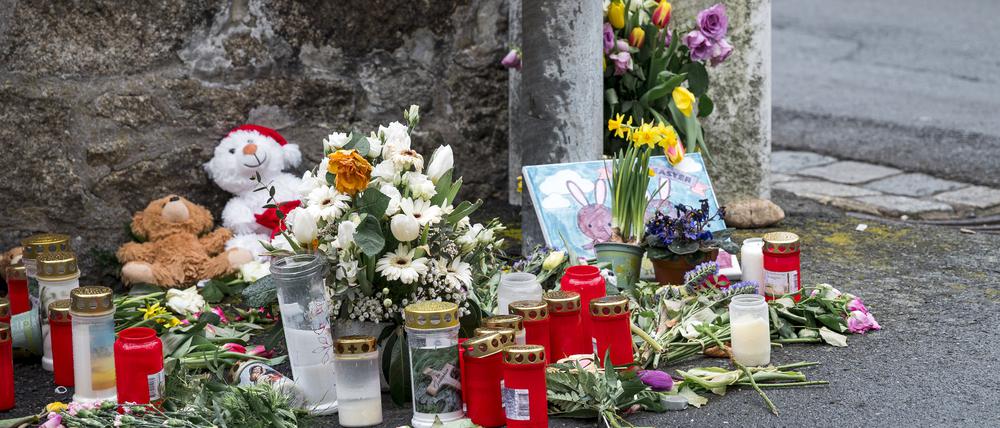 An einer Mauer vor dem Kinder- und Jugendhilfezentrum, in dem eine Zehnjährige tot aufgefunden wurde, liegen Blumen, Kuscheltiere und Kerzen.
