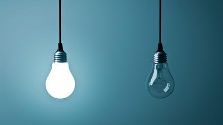 Two hanging light bulbs , One glowing and one turned off on dark green blue background . 3D rendering.
