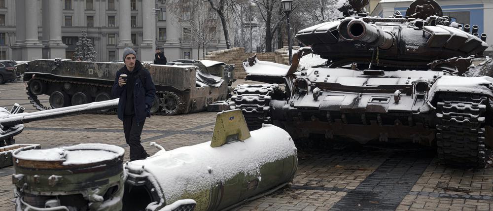Menschen gehen an einer Ausstellung zerstörter russischer Panzer und gepanzerter Fahrzeuge vorbei, nachdem es in der Innenstadt geschneit hat.