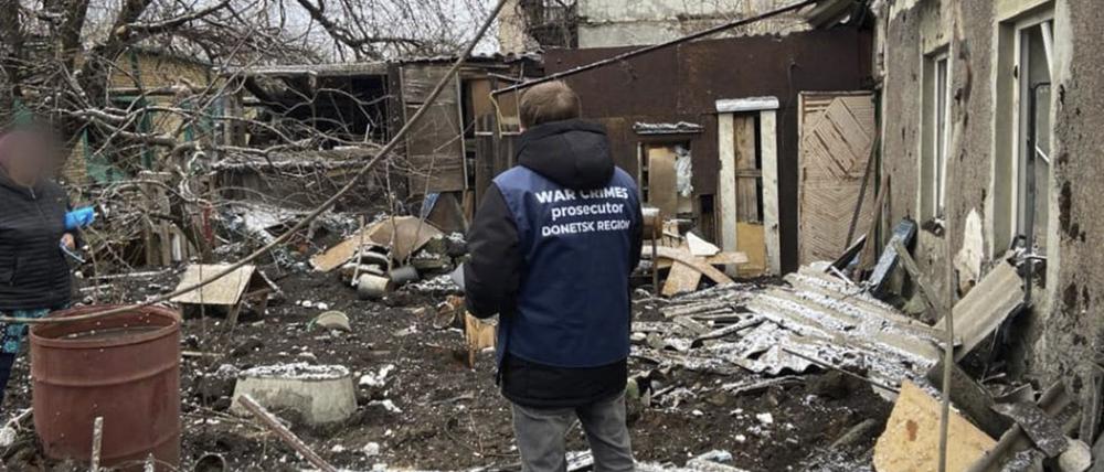 Ukrainischer Staatsanwalt für Kriegsverbrechen bei der Inspektion von Trümmern nach einem Beschuss.