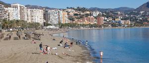Menschen genießen das warme Wetter am Strand von Malaga.