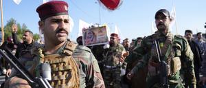 Mitglieder einer irakisch-schiitischen Miliz tragen den Sarg eines Kämpfers, der bei einem US-Luftangriff getötet wurde.