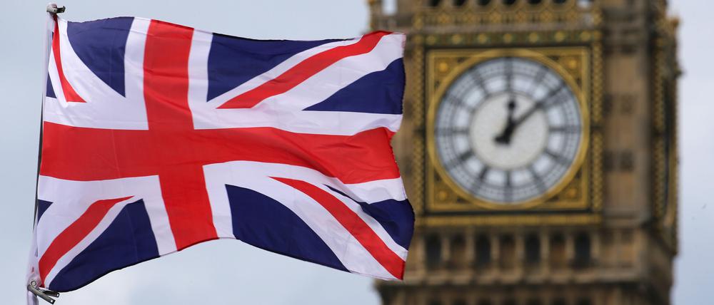 Eine britische Fahne weht vor dem berühmten Uhrturm Big Ben.