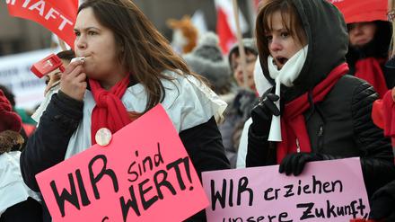 Zwei junge Frauen zeigen am 26.01.2017 in Berlin bei einem Streik der Berliner Erzieher und Sozialpädagogen Schilder mit der Aufschrift „Wir sind es wert“ und „Wir erziehen unsere Zukunft, wir sind mehr wert!“. 