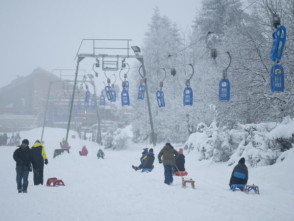 Im Harz ist der Winter ebenso angekommen. Am Rodellift „Brockenblick“ sind Wintersportler auf einer Schlittenpiste unterwegs.