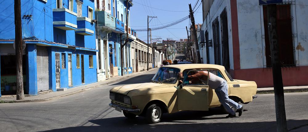 Ein Mann schiebt sein kaputtes Auto durch eine Straße in der kubanischen Hauptstadt. Das Land steckt in einer schweren Wirtschaftskrise. 