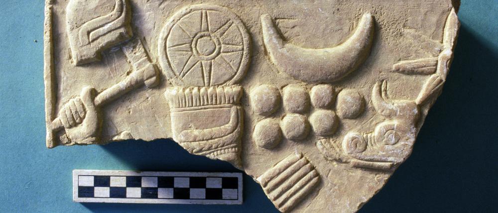 Stück der FU-Sammlung: ein reliefiertes Steinplattenfragment aus Tell Schech Hamad. Es zeigt den Wettergott Hadad (mit Hand und Kopfschmuck).