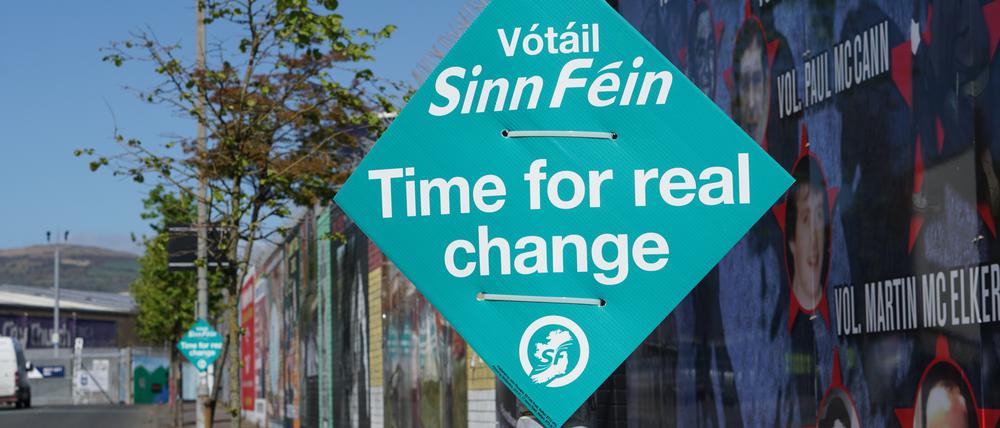 Ein Wahlplakat der Partei Sinn Fein hängt an einem Laternenmast nahe der sogenannten Friedensmauern, die Wohngebiete voneinander abgrenzen (Symbolbild).