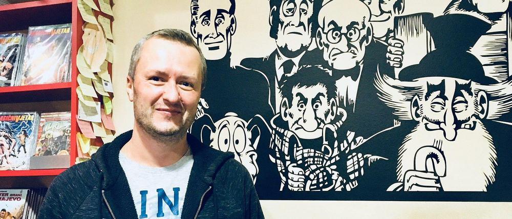 Almir Šehalić vor dem "Alan Ford"-Wandbild in seinem Comicbuchladen.