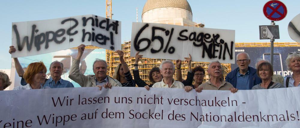Demonstranten mit Plakaten protestieren gegen den Beschluss des Parlaments, das Einheitsdenkmal am Schloss zu errichten. Bis zur Bundestagswahl wollen sie jeden Tag gegen das geplante Denkmal demonstrieren.