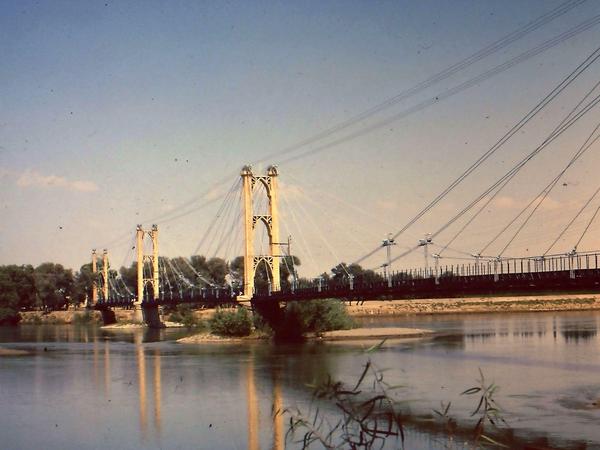 Die Hängebrücke von Deir ez Zor über den Euphrat. Diese von der französischen Mandatsverwaltung 1927 errichtete Fußgängerbrücke - hier eine Aufnahme von 1977 - war lange Zeit die einzige Brücke über den Euphrat. Später wurde eine moderne Brücke parallel errichtet. 