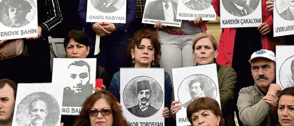 Türkische und armenische Demonstranten halten Fotos von Opfern des Völkermords an den Armeniern 1915 hoch, bei einer Gedenkverstanstaltung 2014. 