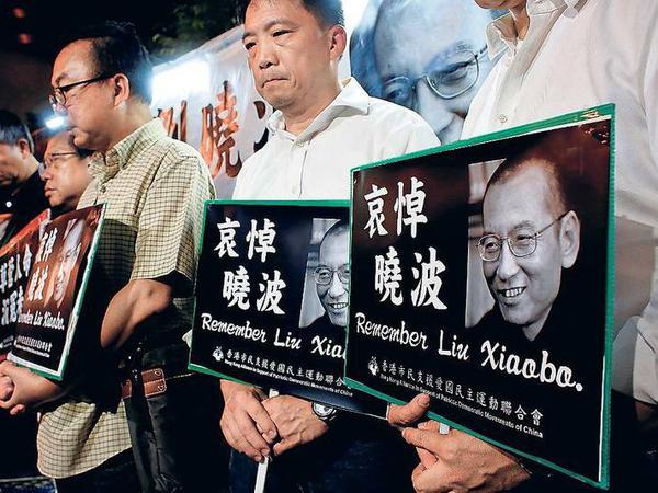 Stumme Demonstration. Hongkong-Chinesen mit dem Foto des inhaftierten Friedensnobelpreisträgers Liu Xiaobo, der am Donnerstag starb.