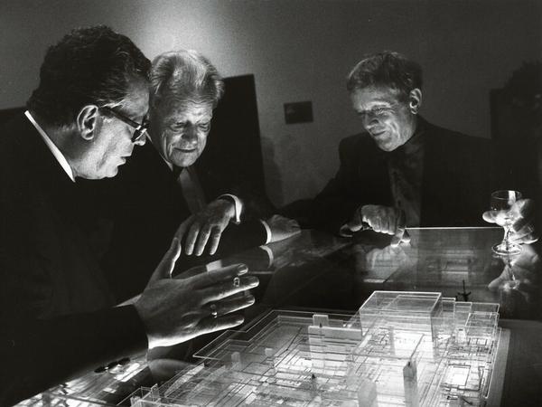 Intendant Götz Friedrich, Willy Brandt und der Architekt Fritz Bornemann betrachten Mitte der Achtzigerjahre ein Modell der Deutschen Oper Berlin. 