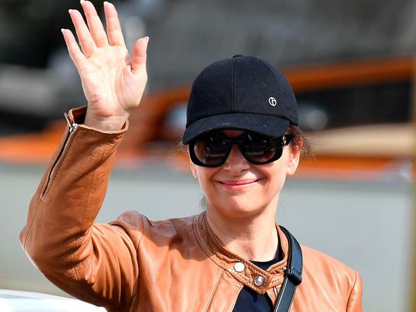 Die französische Schauspielerin Juliette Binoche schützt sich mit Cap und Brille vor der grellen Sonne.