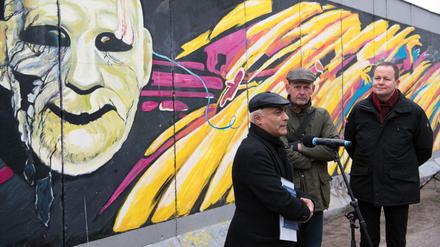 Kani Alavi (l.), Gründer der Künstlerinitiative East Side Gallery e.V., Axel Klausmeier (M.), Direktor der Stiftung Berliner Mauer, und Klaus Lederer (Die Linke), Berlins Kultursenator, vor der East Side Gallery.