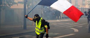 Ein Demonstrant der "Gelbwesten" schwenkt eine französische Flagge während einer Demonstration am Internationalen Tag der Arbeit.
