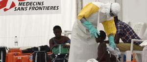 Ein Mitarbeiter der Organisation "Ärzte ohne Grenzen" untersucht in Liberia ein Mädchen auf Ebola. 