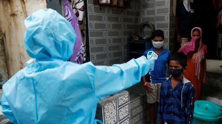 Temperaturmessung. Indische Gesundheitshelferinnen bei einem Einsatz gegen die Verbreitung des Coronavirus in einem Slum in Mumbai. 