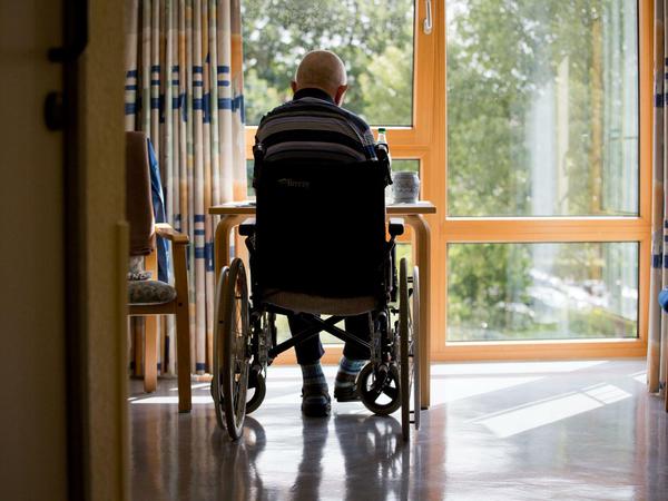 Ein Bewohner eines Altenpflegeheims sitzt in seinem Rollstuhl.