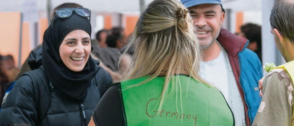 Begrüßung in Passau: Eine Helferin spricht im Herbst 2015 am Bahnhof mit syrischen Flüchtlingen.