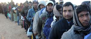 Die erste Flucht: Im März 2011, nach Beginn der alliierten Luftangriffe auf Libyen, bringen sich Arbeitsmigranten aus Bangladesh nahe dem Grenzübergang Ras Jedir nach Tunesien in Sicherheit. Die Grenzlinie, die sie und andere damals nutzten, soll jetzt verschlossen werden.