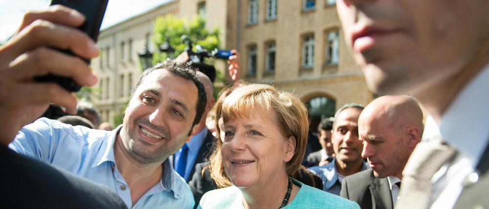Angela Merkel posiert vor einer Berliner Schule mit einem Flüchtling für ein Selfie. CDU-Funktionäre aus acht Bundesländern kritisieren die Bundeskanzlerin für ihre Flüchtlingspolitik. 