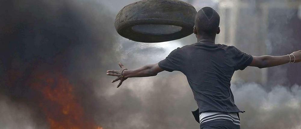 Der Kampf um eine dritte Amtszeit des Präsidenten Pierrre Nkurunziza ist nicht ausgestanden. Ein Demonstrant in der Hauptstadt Bujumbura wirft Reifen auf brennende Barrikaden. Seit mehr als vier Wochen wird in der Hauptstadt fast täglich demonstriert. 