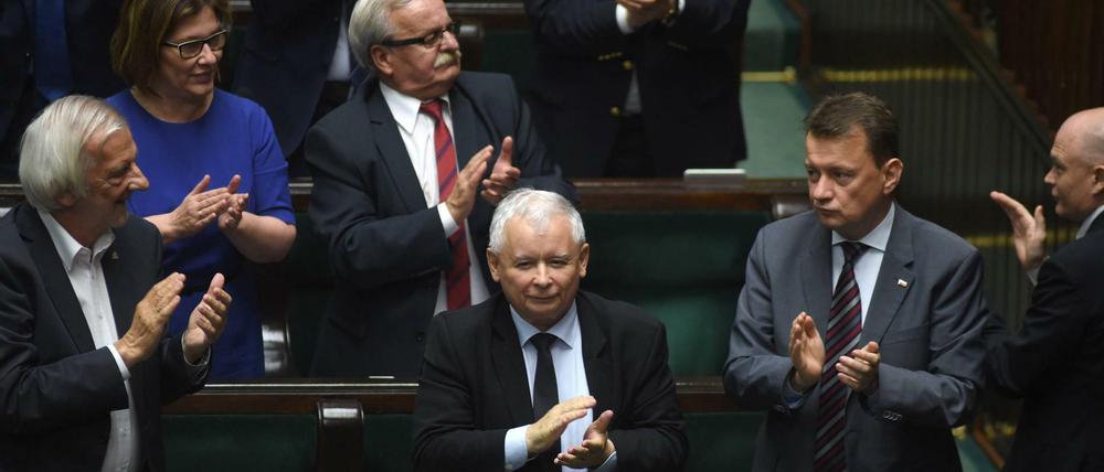Abgeordnete um den Chef der Regierungspartei PiS, Jaroslaw Kaczynski (Mitte), applaudieren. 
