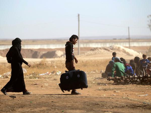 Menschen fliehen bei Aleppo an einem von Rebellen kontrollierten Checkpoint aus einem vom IS kontrollierten Bereich.