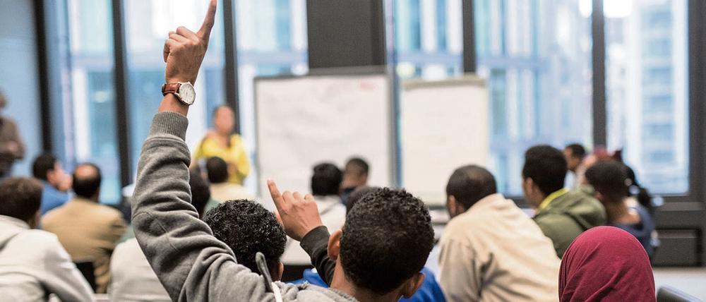Flüchtlinge sitzen in Frankfurt am Main beim Deutschunterricht. 