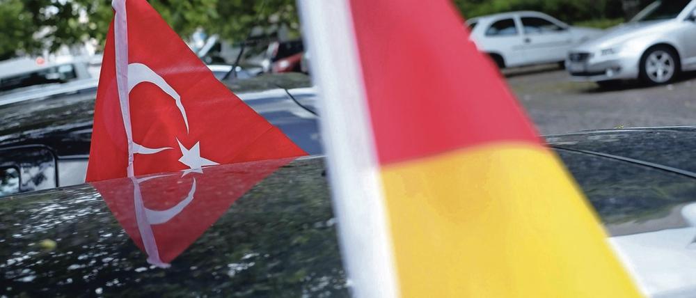 Deutschlandfahne und türkische Flagge an einem Auto in Berlin. 