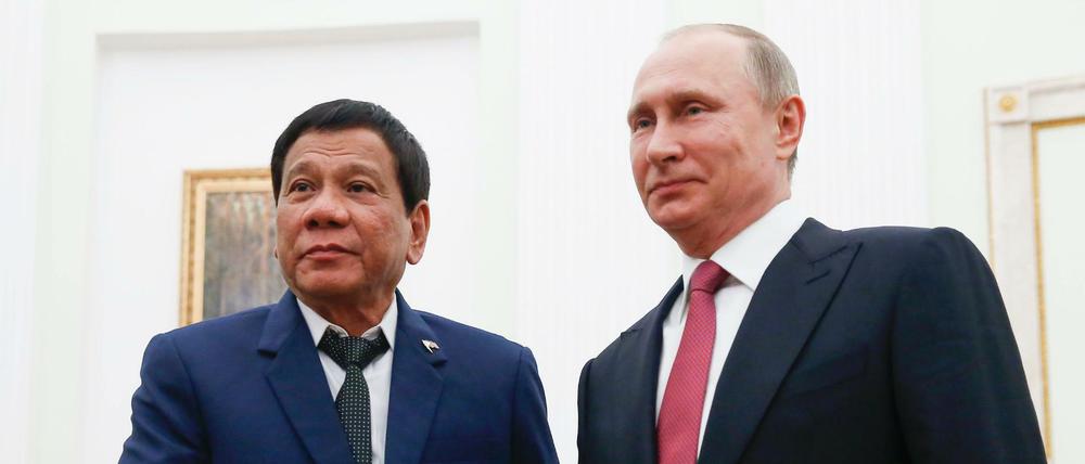 Der Präsident der Philippinen, Rodrigo Duterte (l), und der russische Staatschef Wladimir Putin geben sich am Dienstag in Moskau die Hand.