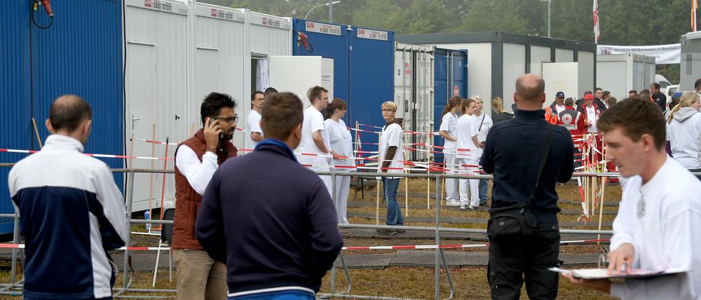 Medizinisches Personal und Flüchtlinge in Rendsburg (Schleswig-Holstein) vor der in Containern untergebrachten medizinischen Erstversorgungseinrichtung. 
