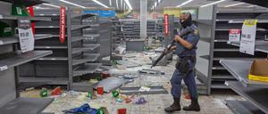 Ein Polizist geht durch ein geplündertes Geschäft in Johannesburg.
