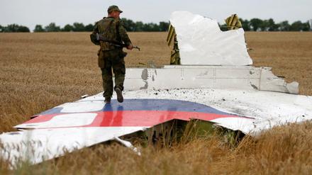 Ein prorussischer Separatist steht auf einem Wrackteil der MH17.
