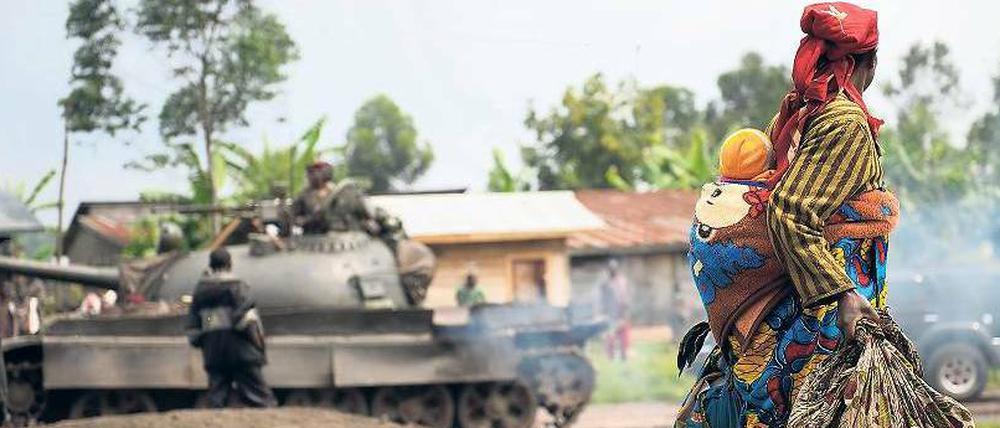 Unschuldige Opfer. Eine Frau flieht mit ihrem Kind vor den Auseinandersetzungen von Regierungstruppen und Rebellen in der Demokratischen Republik Kongo.