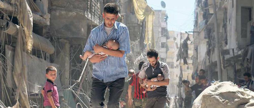 Nach dem Bombardement. Männer haben Babys geborgen und bewegen sich durch die Trümmer von Aleppo. Foto: Ameer Alhalbi/AFP