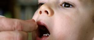Glaubenssache Globuli: Ein kleiner Junge bekommt homöopathische Zuckerkügelchen verabreicht. 