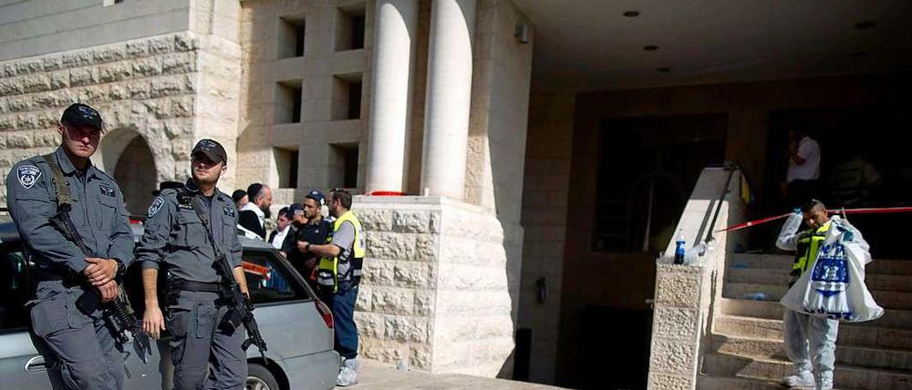 Nach dem Anschlag reinigt ein Mann den Boden vor der Synagoge.