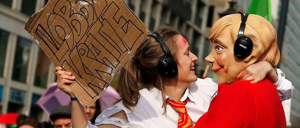 Eine Merkel-Puppe lässt sich von einer Lobbyistin küssen. Bei der Klimademonstration in Berlin am Sonntag haben rund 10 000 Menschen eine bessere Klimapolitik verlangt. Sie zogen in drei Demonstrationszügen zum Brandenburger Tor. 